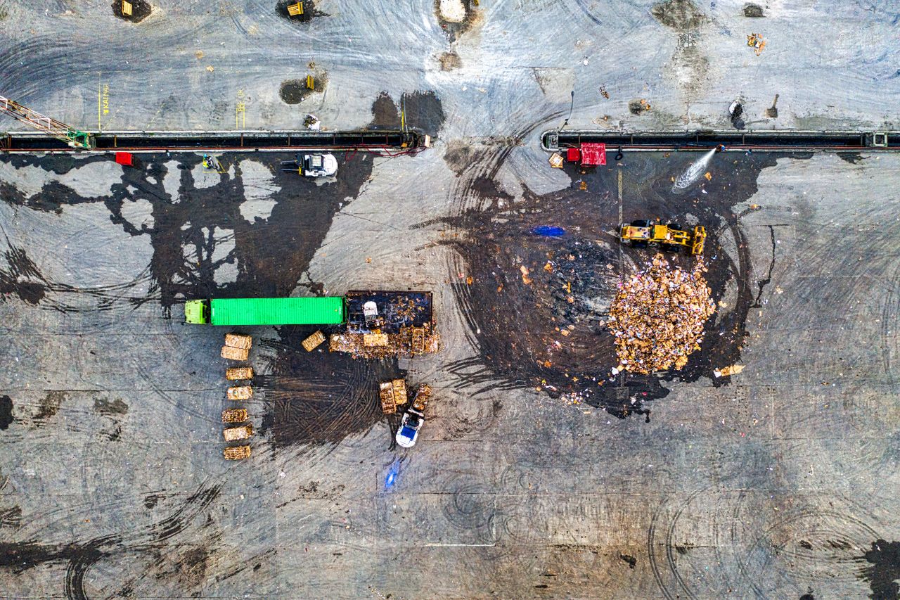 Aerial shot of waste processing site with heavy equipment and trucks in Serang, Indonesia.